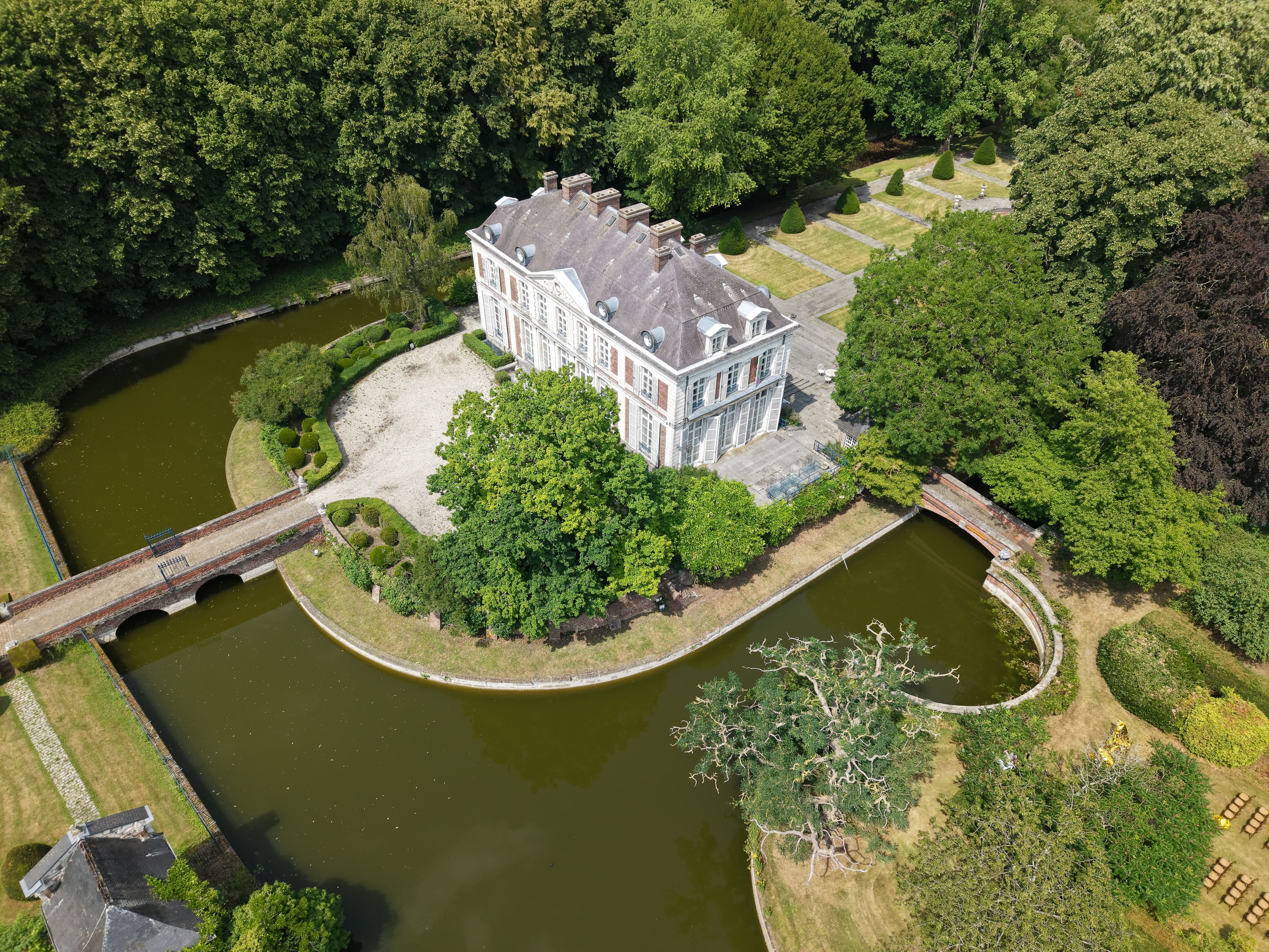 Vue aérienne d'un domaine avec cérémonie de mariage en extérieur et rangées de chaises
